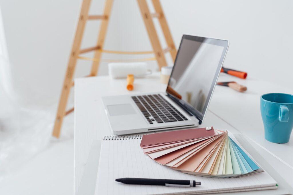 Arbeitsplatz mit Laptop und Farbmuster zur Büroeinrichtung | Fußbodenheizung fräsen